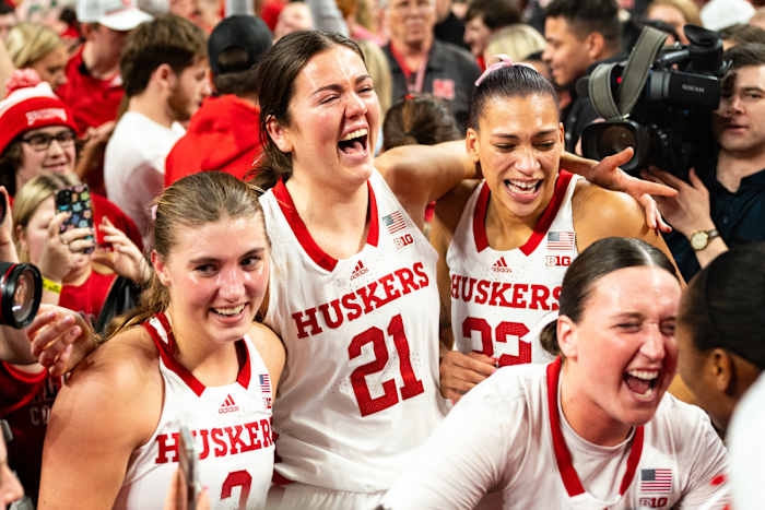 Feb 11, 2024; Lincoln, Nebraska, USA; The Nebraska Cornhuskers celebrate as fans storm the court after defeating the Iowa Hawkeyes at Pinnacle Bank Arena.